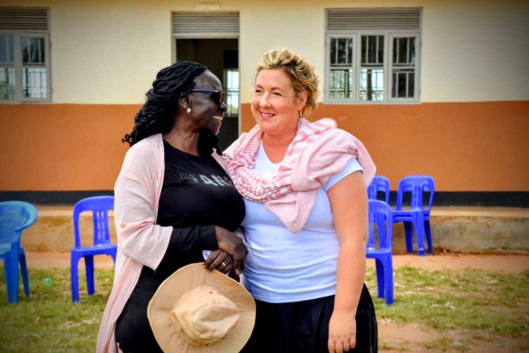 PJF co-founders Gloria Laker Adiiki Aciro and Sarah Bradford smiling together outside a classroom at Kweyo Primary School